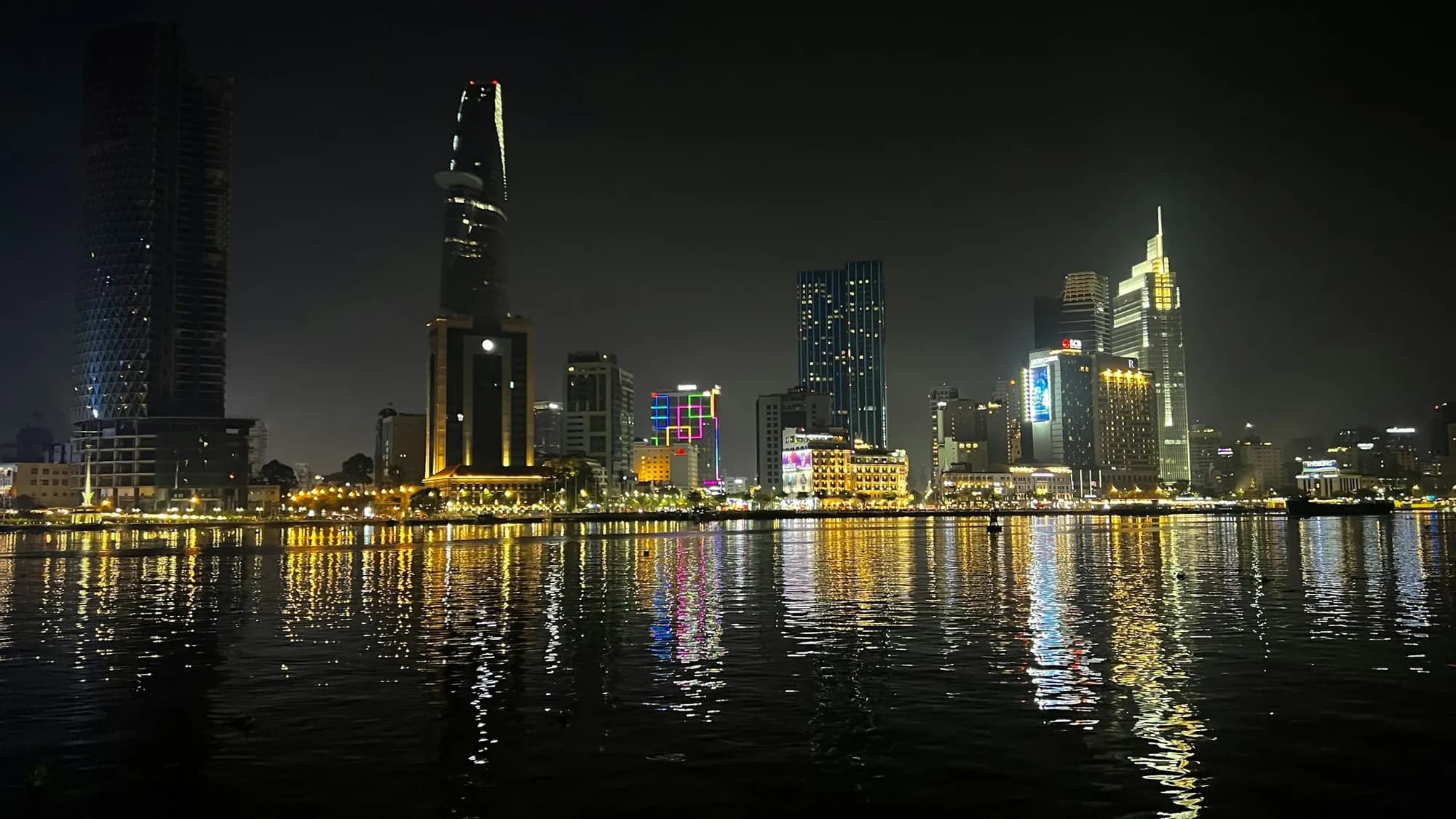 Sharjah's Al Majaz waterfront at night, towers reflected in the lagoon
